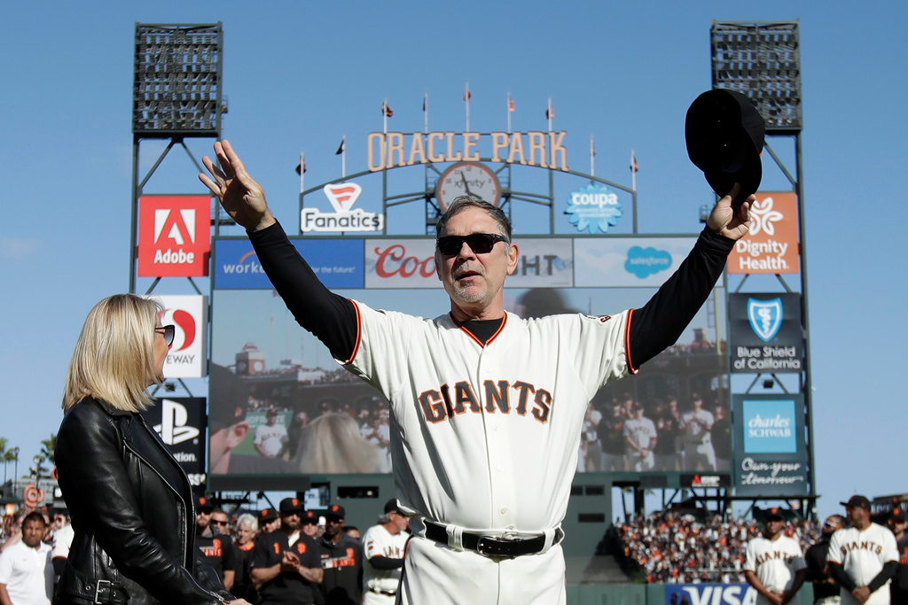 FILE - San Francisco Giants manager Bruce Bochy, center, gestures toward fans next to his wife Kim during a ceremony honoring Bochy after a baseball game between the Giants and the Los Angeles Dodgers in San Francisco, Sept. 29, 2019. (AP Photo/Jeff Chiu, Pool, File)