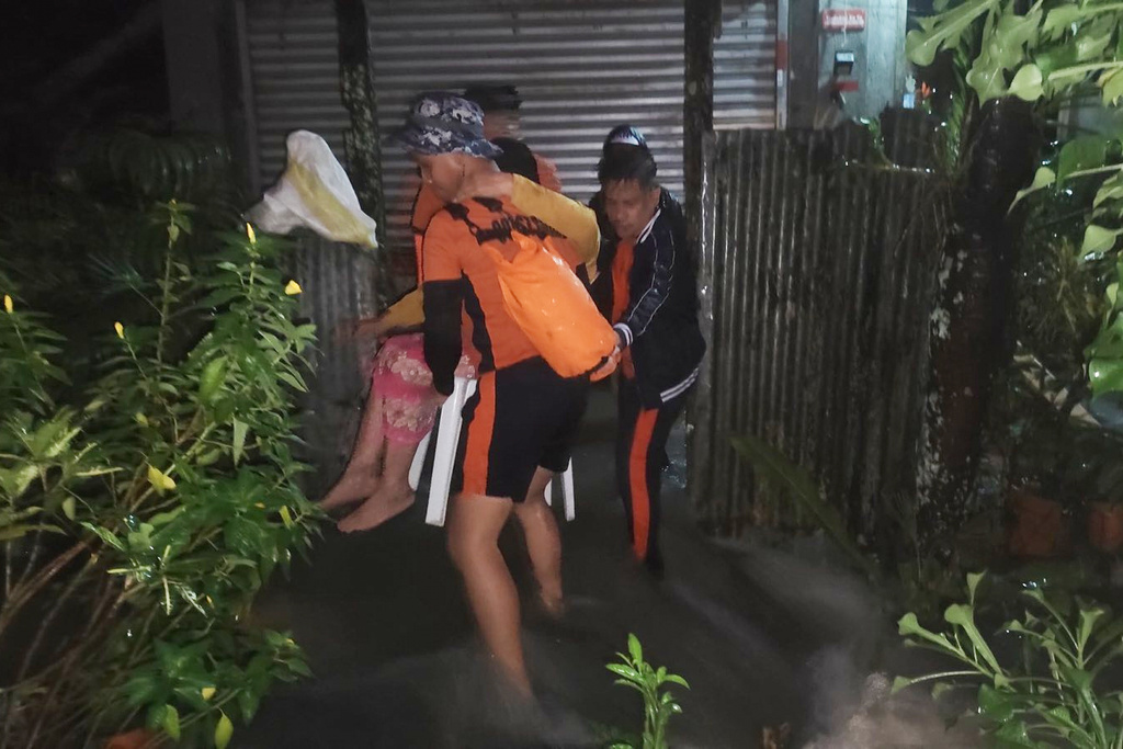 In this handout provided by the Philippine Coast Guard, rescuers evacuate a resident as floods rise due to Typhoon Bualoi in Ormoc, Leyte province, Philippines, on Friday Sept. 26, 2025. (Philippine Coast Guard via AP)