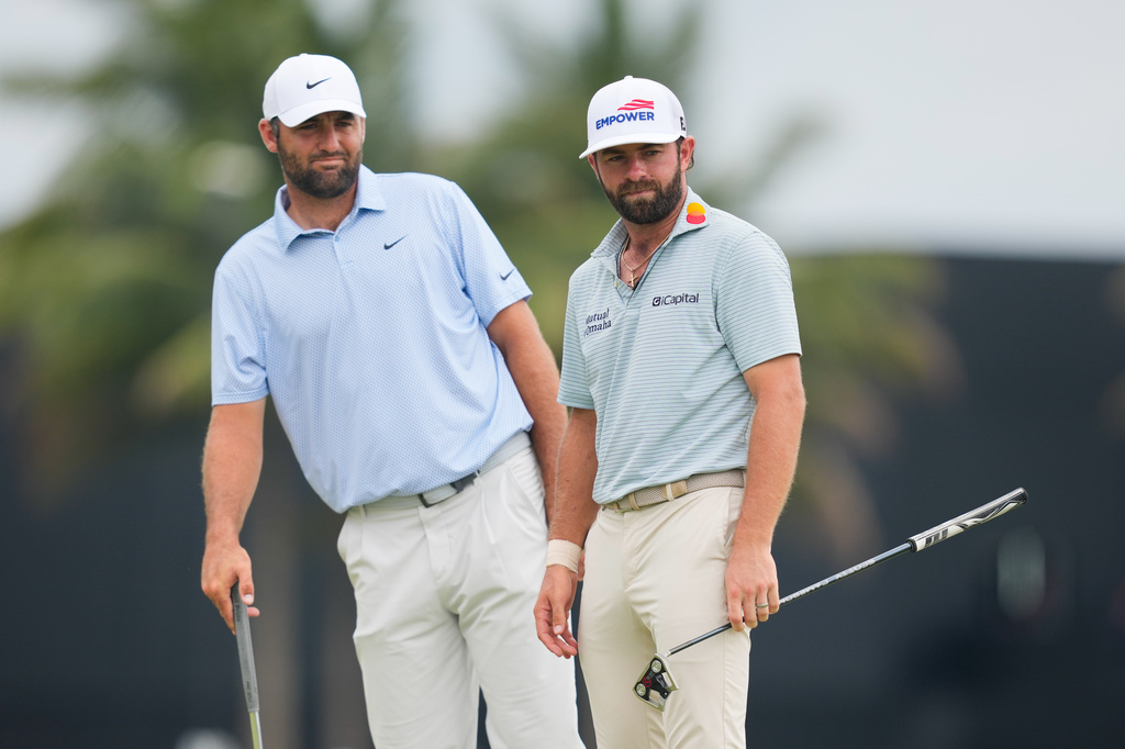 Scottie Scheffler, left, leans to watch Cameron Young's putt on the ninth green during the final round of the Cadillac Championship PGA golf tournament Sunday, May 3, 2026, in Doral, Fla. (AP Photo/David J. Phillip)