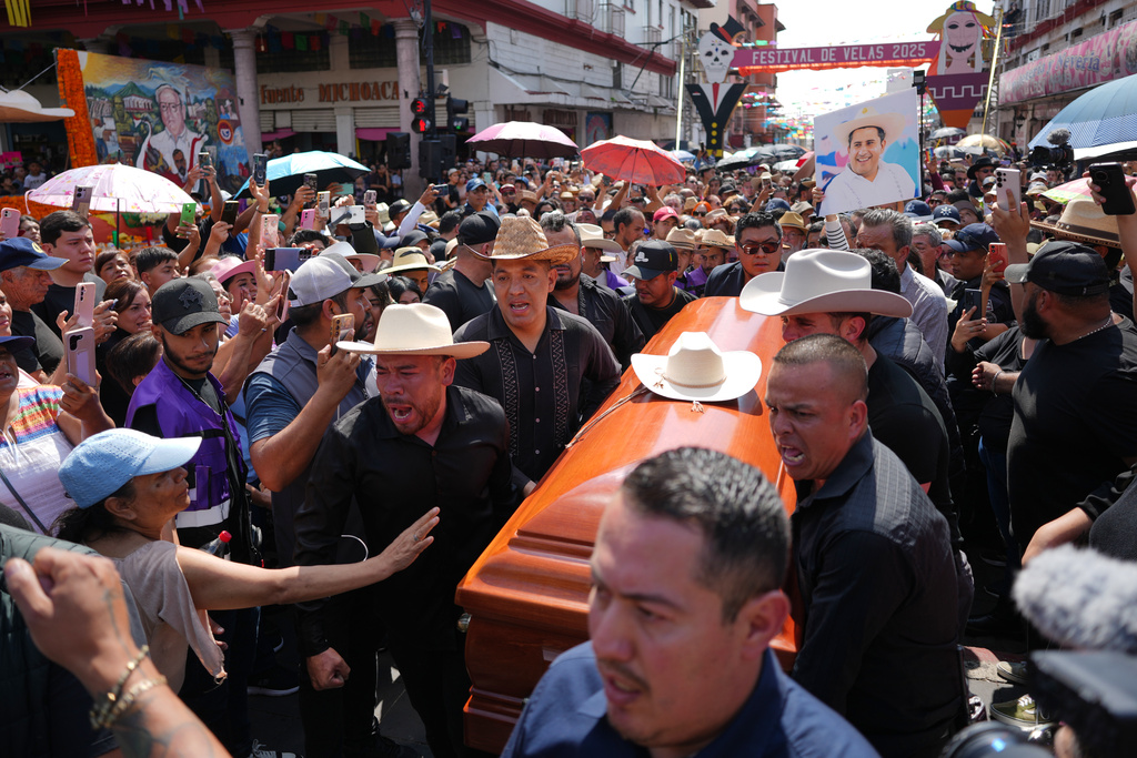 People carry the coffin of late Mayor Carlos Manzo Rodriguez, who was shot during Day of the Dead celebrations, in Uruapan, Michoacan state, Mexico, Sunday, Nov. 2, 2025. (AP Photo/Eduardo Verdugo)