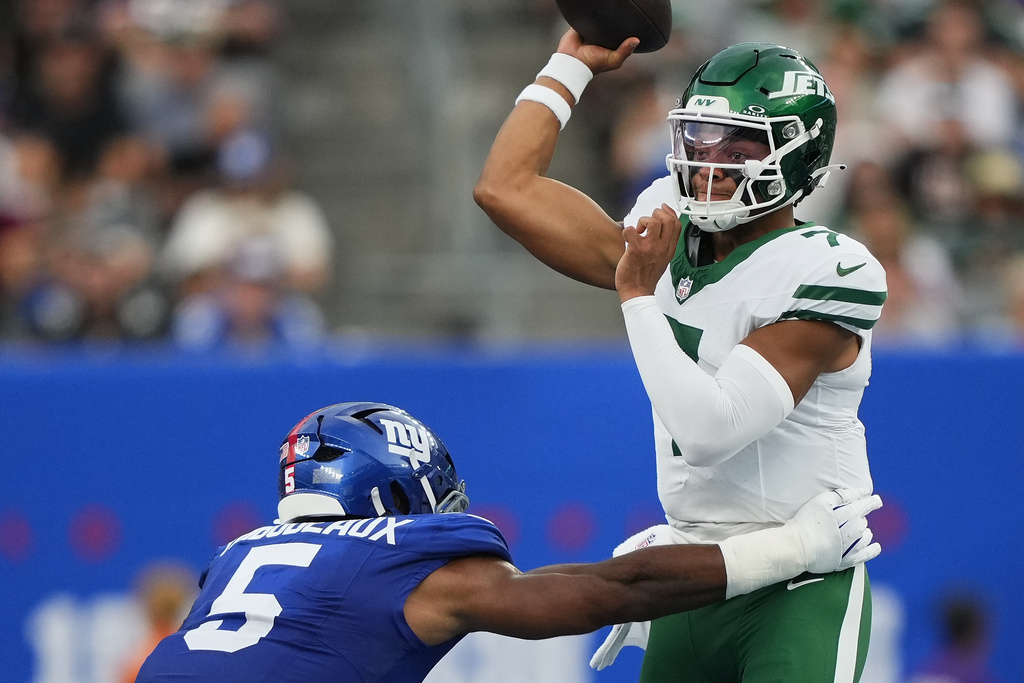 New York Jets quarterback Justin Fields (7) throws under pressure from New York Giants linebacker Kayvon Thibodeaux (5) during the first quarter of an NFL football game, Saturday, Aug. 16, 2025, in East Rutherford, N.J. (AP Photo/Yuki Iwamura)