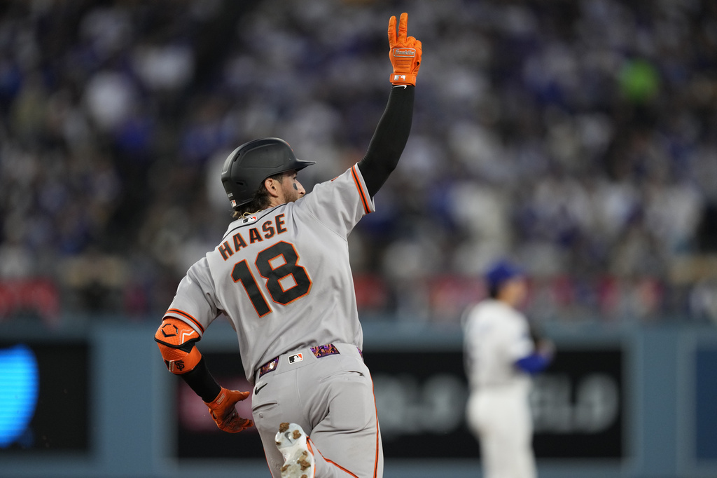 San Francisco Giants' Eric Haase, gestures as he rounds first after hitting a solo home run during the third inning of a baseball game against the Los Angeles Dodgers, Tuesday, May 12, 2026, in Los Angeles. (AP Photo/Mark J. Terrill)