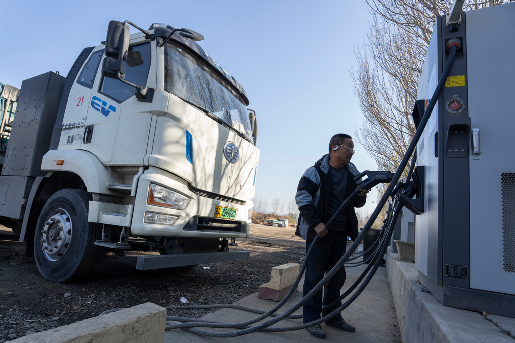 A driver charges his electric truck at a charging station on the outskirts of Beijing, on Nov. 14, 2025. (AP Photo/Ng Han Guan)