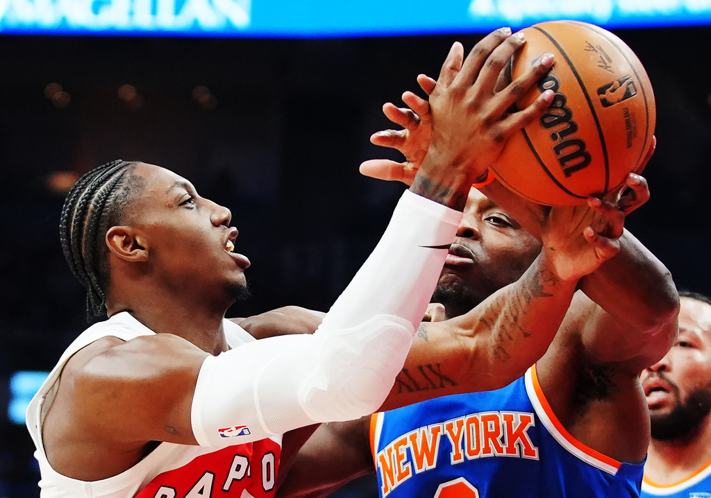 Toronto Raptors' RJ Barrett (left) is fouled by New York Knicks' Og Anunoby (8) during first half NBA basketball action in Toronto on Wednesday, Jan. 28, 2026. (Frank Gunn/The Canadian Press via AP)