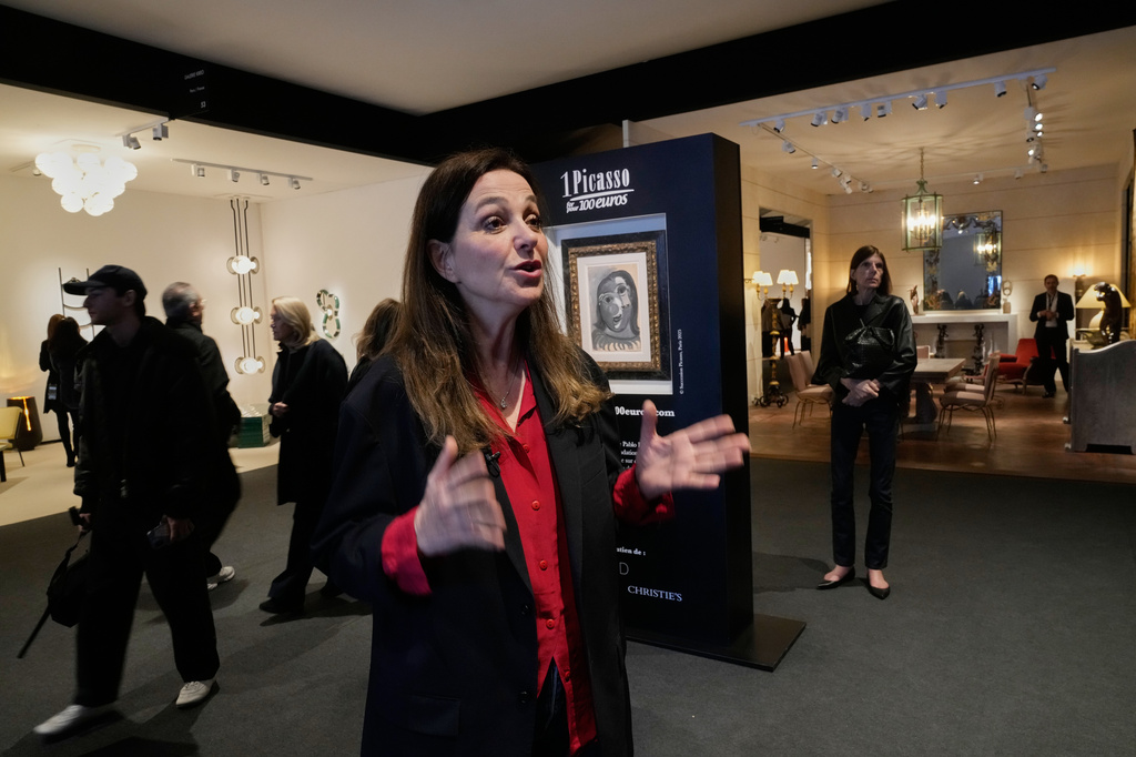 Peri Cochin, co-founder of the "1 Picasso for 100 euros" lottery, speaks during an Associated Press interview, next to Head of a Woman by Pablo Picasso, painted in 1941, in Paris, Friday, April 10, 2026, where the draw will be handled by auction house Christie's next week. (AP Photo/Michel Euler)