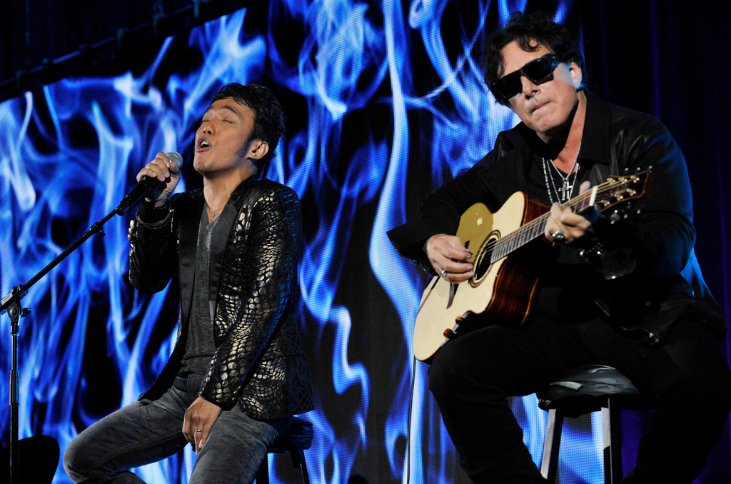 FILE - Arnel Pineda, left, and Neal Schon, of the rock band Journey, perform after a panel discussion on the Independent Lens documentary "Don't Stop Believin': Everyman's Journey," at the PBS Summer 2013 TCA press tour in Beverly Hills, Calif., on Aug. 6, 2013. (Photo by Chris Pizzello/Invision/AP, File)