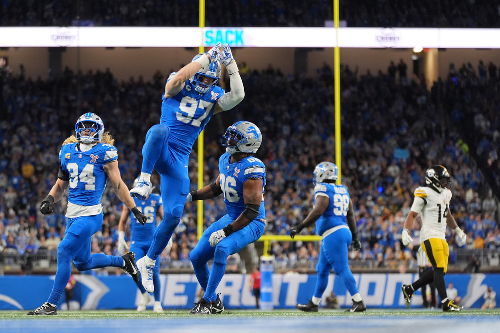 FILE - Detroit Lions' Alex Anzalone (34), Aidan Hutchinson (97) and Al-Quadin Muhammad (96) celebrate after a sack during the first half of an NFL football game against the Pittsburgh Steelers, Dec. 21, 2025, in Detroit. (AP Photo/Ryan Sun, File)