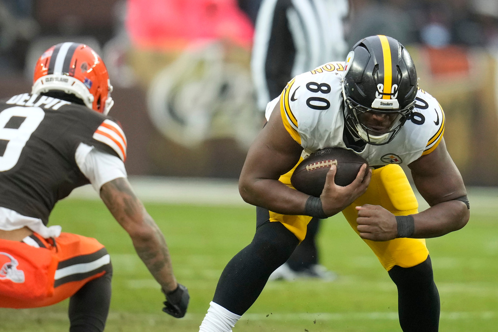 Pittsburgh Steelers tight end Darnell Washington (80) catches a pass in front of Cleveland Browns safety Grant Delpit (9) during the first half of an NFL football game, Sunday, Dec. 28, 2025, in Cleveland. (AP Photo/Sue Ogrocki)