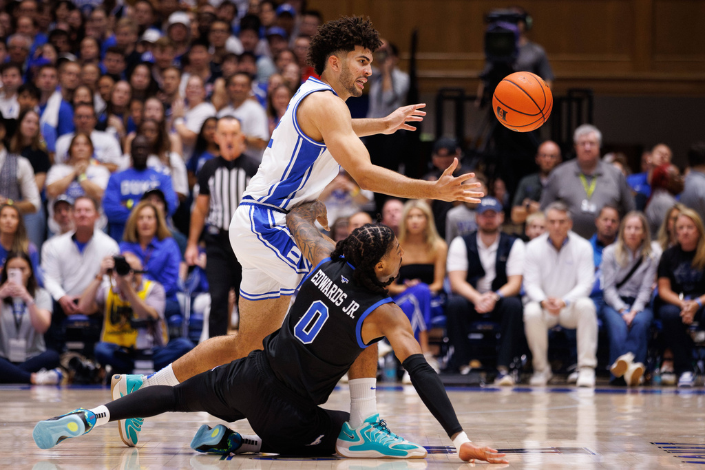 Duke's Cameron Boozer, left, and SMU's B.J. Edwards (0) chase a loose ball during the first half of an NCAA college basketball game in Durham, N.C., Saturday, Jan. 10, 2026. (AP Photo/Ben McKeown)