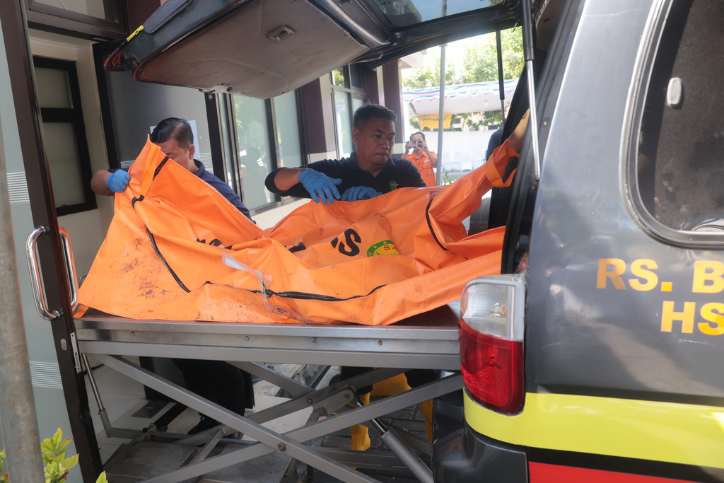 Rescuers remove the newly-recovered body of a victim of a building that collapsed at an Islamic boarding school from an ambulance upon arrival at the police hospital in Surabaya, East Java, Indonesia, Sunday, Oct. 5, 2025. (AP Photo/Trisnadi)