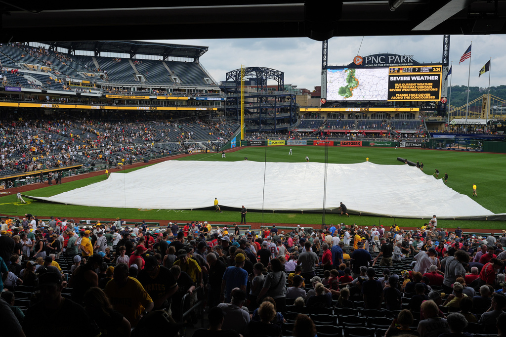 The grounds crew at PNC Park deploys a tarp in preparation for severe weather during a baseball game between the Pittsburgh Pirates and the Boston Red Sox in Pittsburgh, Sunday, Aug. 16, 2026. (AP Photo/Gene J. Puskar)