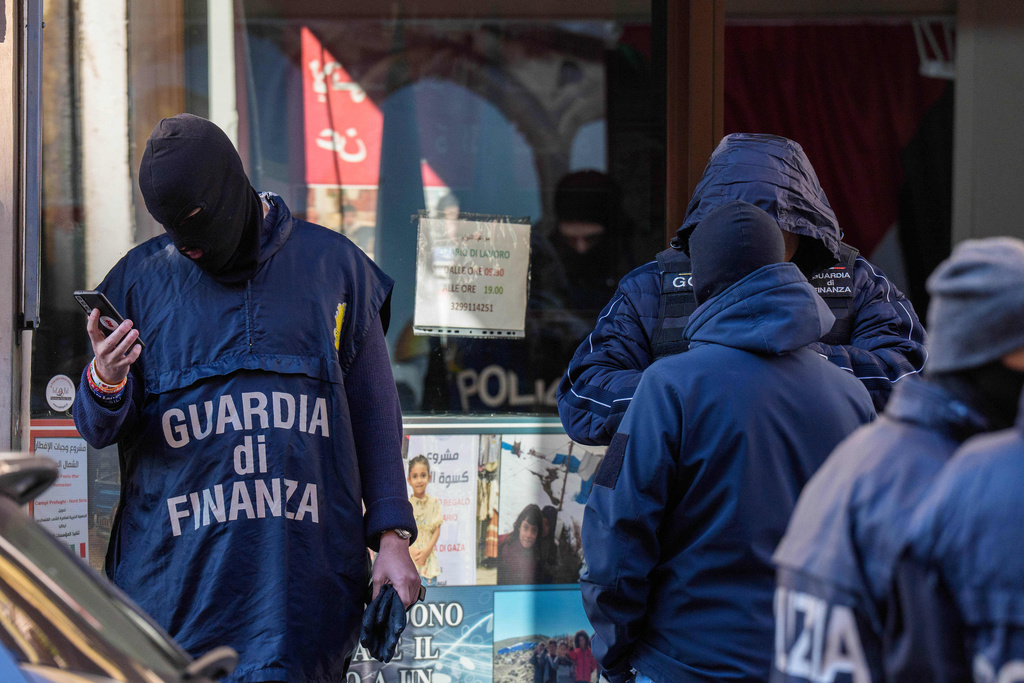 Police officers inspect a charitable association supporting Palestinian civilians in Milan, Italy, Saturday, Dec. 27, 2025 after Italian investigators have arrested nine people suspected of raising millions of euros for Hamas. (Claudio Furlan/LaPresse via AP)