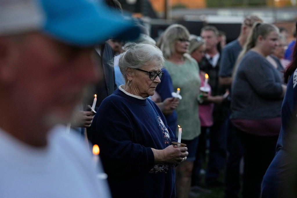 A woman holds a candle vigil honoring the victims of a blast at an explosives plant, Accurate Energetic Systems, Sunday, Oct. 12, 2025, in Waverly, Tenn. (AP Photo/George Walker IV)