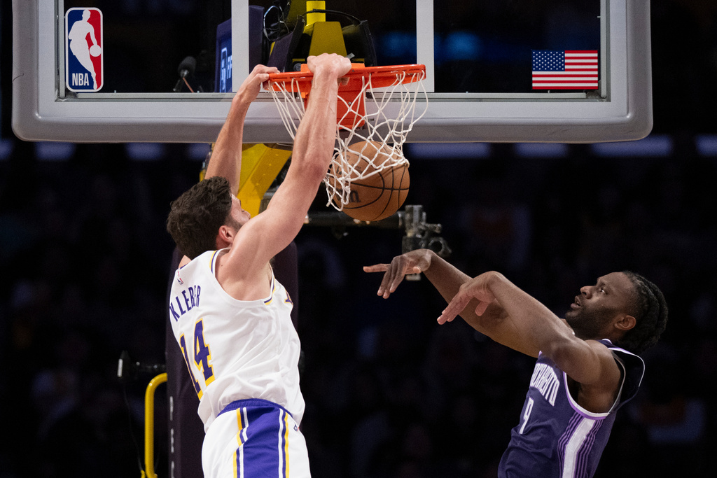 Los Angeles Lakers forward Maxi Kleber, left, dunks past Sacramento Kings forward Precious Achiuwa during the first half of an NBA basketball game in Los Angeles, Sunday, March 1, 2026. (AP Photo/Kyusung Gong)