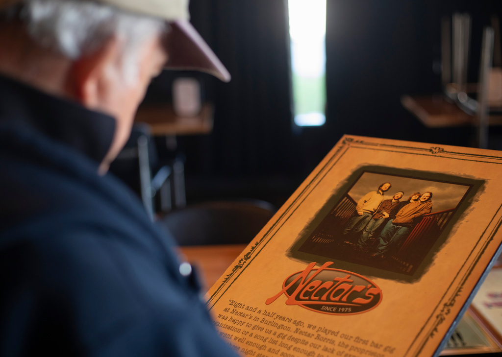 Nectar Rorris, one of the original owners of Nectar's music club in Burlington, Vt., looks at a plaque featuring a photo of the jam band Phish and a message dedicating their 1992 album "A Picture of Nectar" to Rorris and the venue, Thursday, Oct. 2, 2025 in Essex, Vt. (AP Photo/Amanda Swinhart)