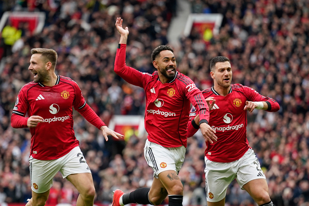 Manchester United's Matheus Cunha, centre, celebrates with teammates after scoring his side's opening goal during the English Premier League soccer match between Manchester United and Liverpool in Manchester, England, Sunday, May 3, 2026. (AP Photo/Dave Thompson)