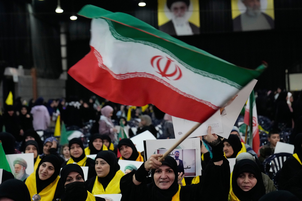 A Hezbollah supporter waves an Iranian flag during a rally to show their solidarity with the Iranian government, in the southern suburb of Beirut, Lebanon, Monday, Jan. 26, 2026. (AP Photo/Hussein Malla)