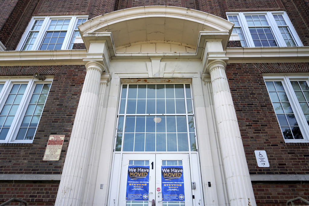 Signs on the front doors of Sumner High School alert visitors classes have been moved after the school was damaged in a recent tornado Sept. 18, 2025, in St. Louis. (AP Photo/Jeff Roberson)