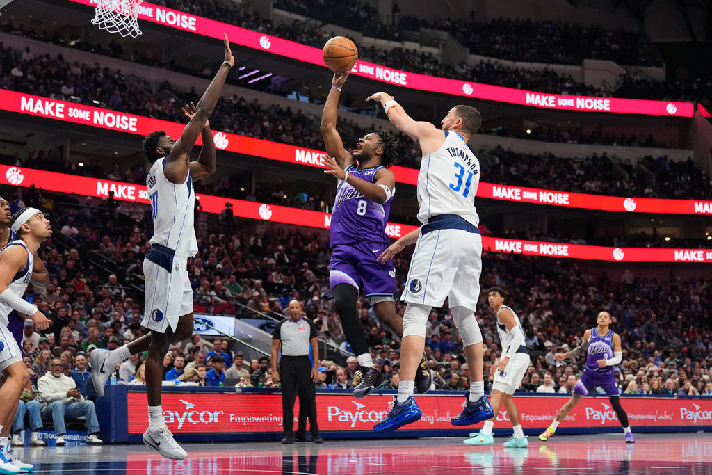 Utah Jazz guard Isaiah Collier (8) shoots as between Dallas Mavericks' Moussa Cisse, and Klay Thompson (31) in the first half of an NBA basketball game in Dallas, Saturday, Jan. 17, 2026. (AP Photo/Tony Gutierrez)