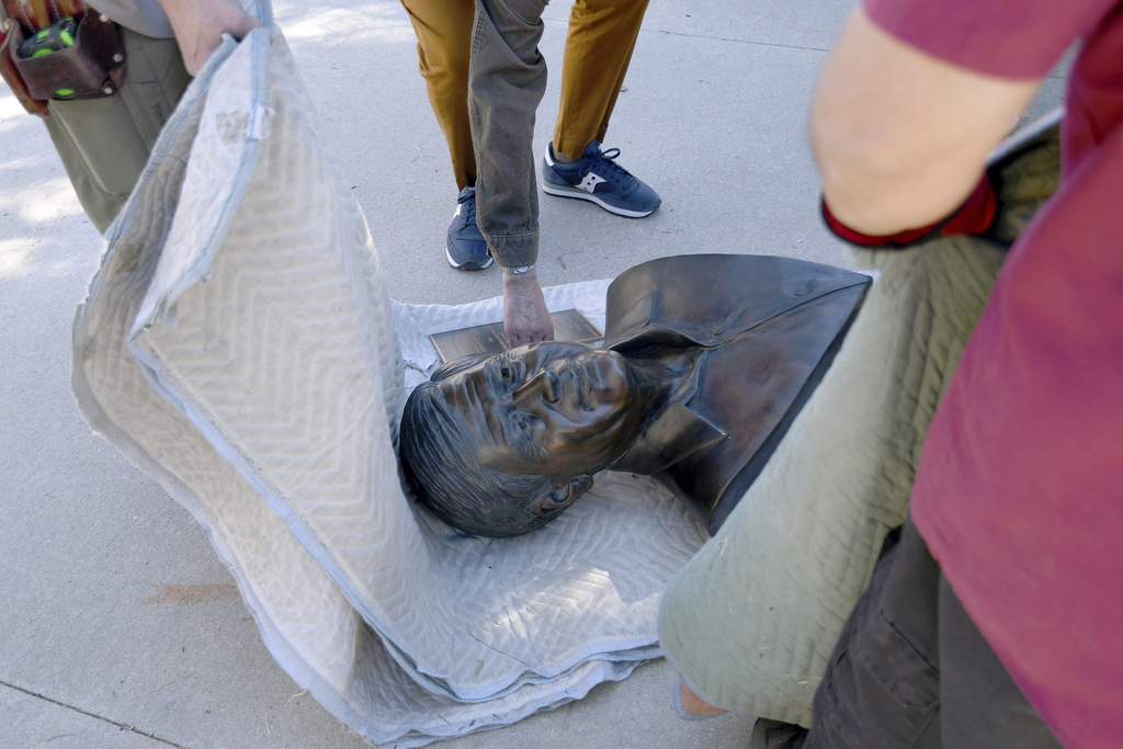 City workers wrap a bust of César Chavez that was removed from César E. Chavez Park in Denver on Thursday, March 19, 2026. (AP Photo/Thomas Peipert)