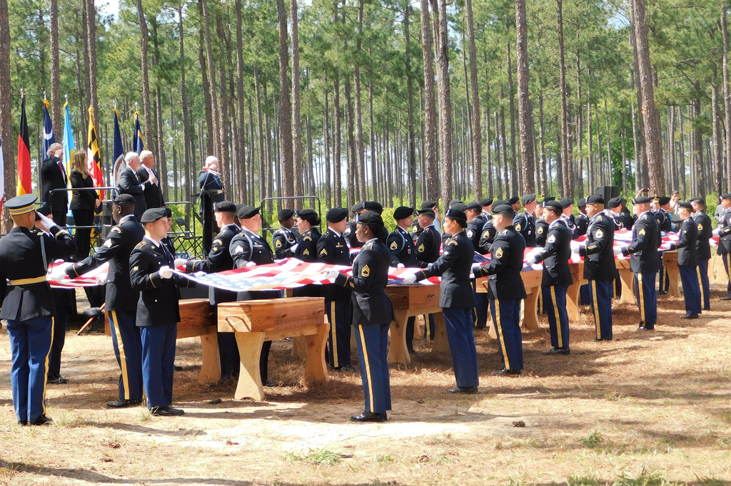 Military personnel fold flags for the remains of 12 Continental soldiers killed at the Battle of Camden, S.C., during a memorial ceremony on April 22, 2023. (Historic Camden Foundation/via AP)