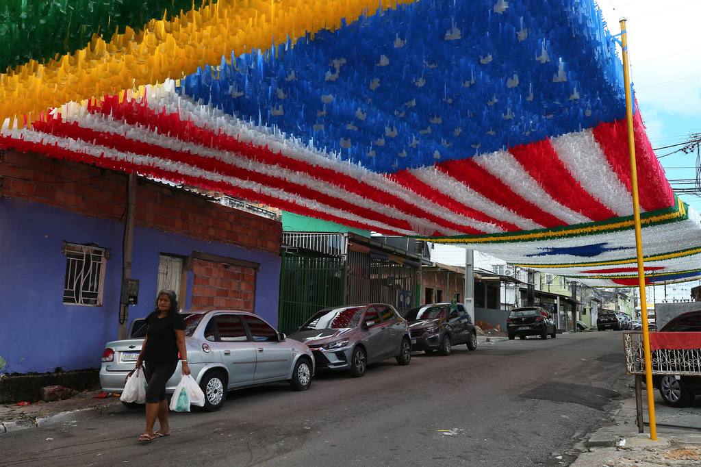 FILE- A pedestrian walks beneath street decorations set up in tribute to the upcoming FIFA World Cup, in Manaus, Brazil, May 17, 2026. (AP Photo/Edmar Barros)