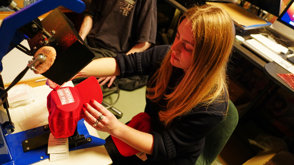 A worker prints red caps for sale covered by the slogan "Nu det NUUK!," a twist on the Danish phrase “Nu det nok,” meaning “Now it’s enough,” substituting Nuuk, Greenland’s tiny capital, a the store of the hat's creator Jesper Rabe Tonnesen in Copenhagen, Denmark, Friday, Jan. 16, 2026. (AP Photo/James Brooks)