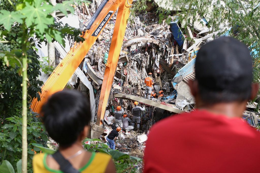 Relatives and family members watch as rescuers continue operations on a collapsed waste segregation facility in Binaliw, Cebu city, central Philippines on Saturday, Jan. 10, 2026. (AP Photo/Jacqueline Hernandez)