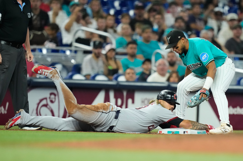 Cleveland Guardians' Gabriel Arias, left, advances to third on a single hit by Steven Kwan during the fourth inning of a baseball game, Sunday, July 12, 2026, in Miami. At right is Miami Marlins third baseman Leo Jiménez. (AP Photo/Lynne Sladky)