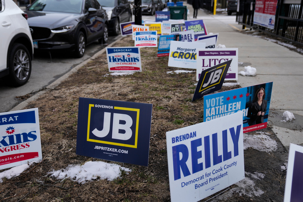 Signs are displayed outside of a polling location at Union Park during the Illinois primary election Tuesday, March 17, 2026, in Chicago. (AP Photo/Erin Hooley)