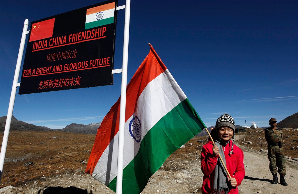 FILE - In this Oct. 21, 2012 file photo, an Indian girl poses for photos with an Indian flag at the Indo-China border in Bumla at an altitude of 15,700 feet (4,700 meters) above sea level in Arunachal Pradesh, India.(AP Photo/Anupam Nath, File)