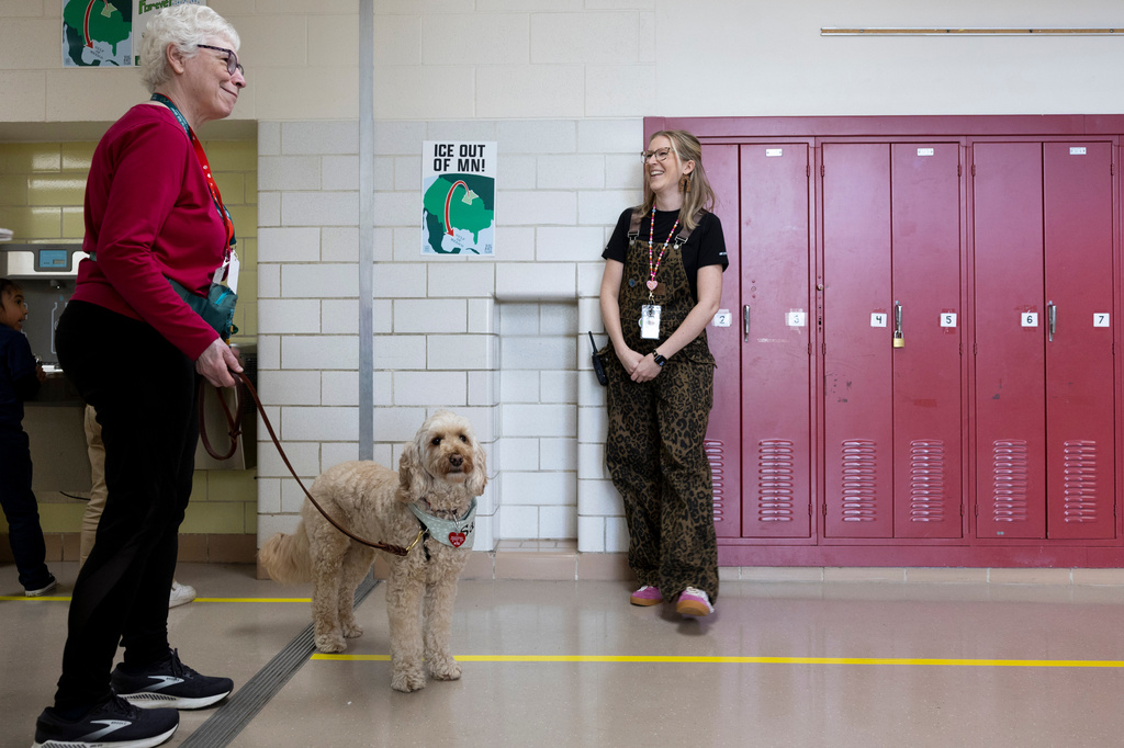 Linda Buchs-Hammonds, left, and her therapy dog, Sage, walk through the hallway at Valley View Elementary School with school social worker Nicole Herje, right, on April 29, 2026, in Columbia Heights, Minn. (Ellen Schmidt/MinnPost via AP)