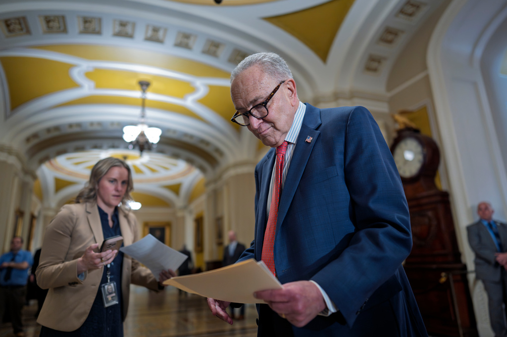 Senate Minority Leader Chuck Schumer, D-N.Y., holds papers following a closed-door strategy session, at the Capitol in Washington, Tuesday, April 14, 2026. (AP Photo/J. Scott Applewhite)