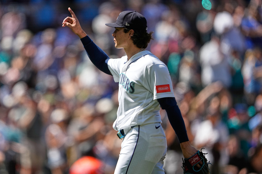 Seattle Mariners starting pitcher Bryan Woo reacts to fans as he walks to the dugout after being relieved during the eighth inning of a baseball game against the Baltimore Orioles, Thursday, June 18, 2026, in Seattle. (AP Photo/Lindsey Wasson)