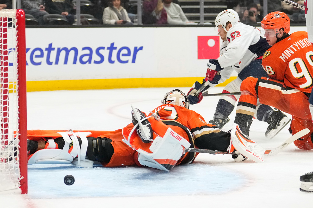 Washington Capitals center Ethen Frank, center, scores on Anaheim Ducks goaltender Ville Husso, left, as defenseman Pavel Mintyukov watches during the second period of an NHL hockey game Friday, Dec. 5, 2025, in Anaheim, Calif. (AP Photo/Mark J. Terrill)