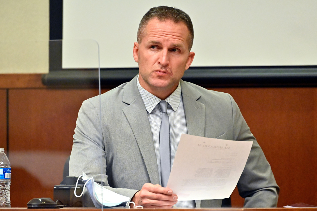 FILE - Former Louisville Police officer Brett Hankison examines a document as he answers questions from the prosecution, March 2, 2022, in Louisville, Ky. (AP Photo/Timothy D. Easley, Pool, File)