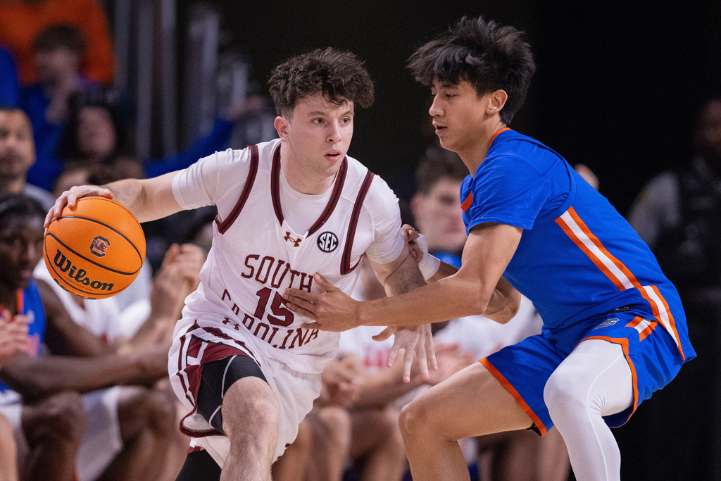 South Carolina guard Eli Ellis (15) drives on Florida Gators guard Xaivian Lee (1) during the first half of an NCAA college basketball game Wednesday, Jan. 28, 2026, in Columbia, S.C. (AP Photo/Scott Kinser)