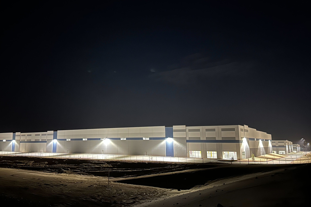 Three hulking warehouses light up the night in Socorro, Texas, Thursday, Feb. 12, 2026, amid concern about the purchase of the property by federal authorities in connection with U.S. Immigration and Customs Enforcement’s $45-billion expansion of immigrant detention centers. (AP Photo/Morgan Lee)