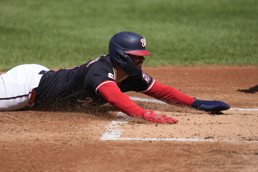 Washington Nationals' Luis Garcia Jr. slides into home plate and scores on a triple hit by Daylen Lile during the second inning of a baseball game against the Miami Marlins at Nationals Park, Monday, Sept. 1, 2025, in Washington. (AP Photo/Jess Rapfogel)