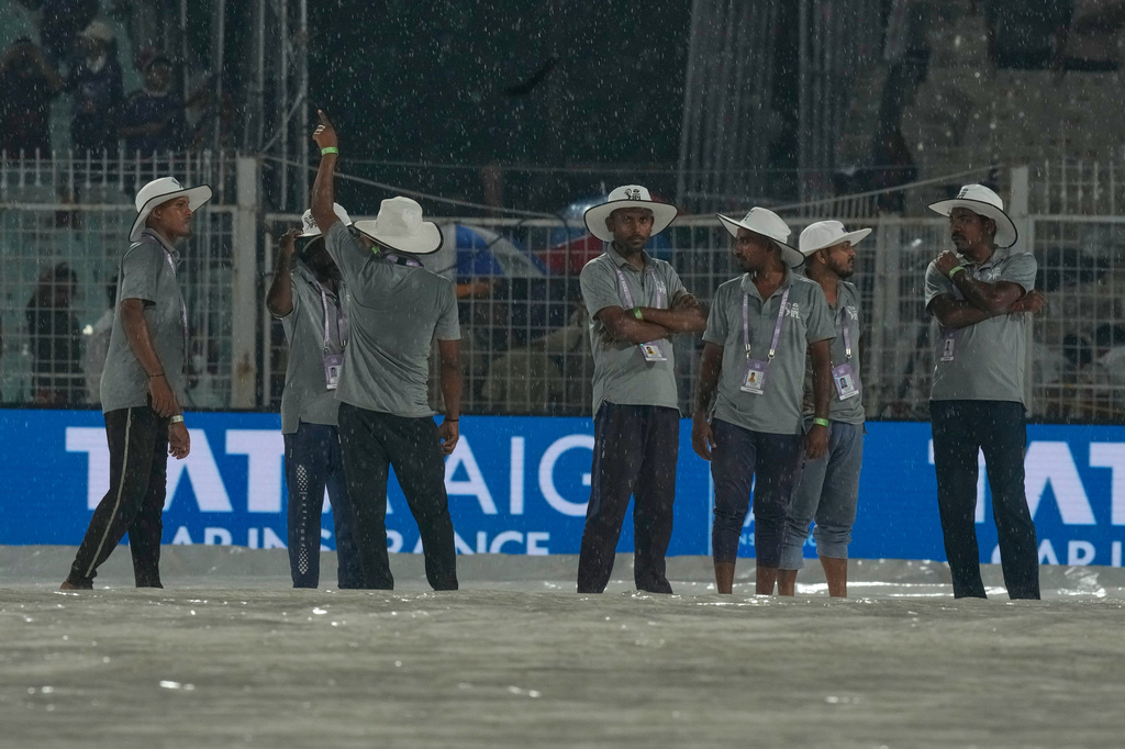 Ground staff stand on rain covers as it rains during the Indian Premier League cricket match between Kolkata Knight Riders and Punjab Kings in Kolkata , India, Monday, April 6, 2026. (AP Photo/Bikas Das)