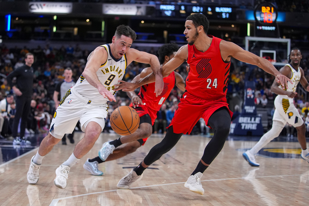 Indiana Pacers guard T.J. McConnell (9) drives on Portland Trail Blazers forward Kris Murray (24) during the first half of an NBA basketball game in Indianapolis, Wednesday, March 18, 2026. (AP Photo/Michael Conroy)
