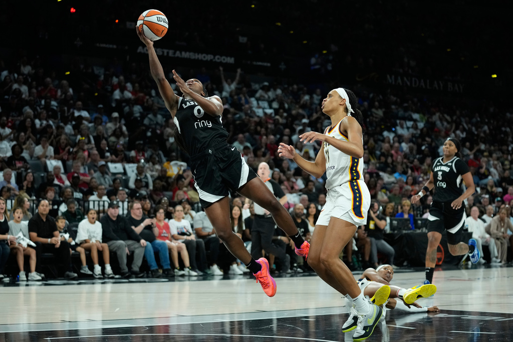 Las Vegas Aces guard Jackie Young (0) shoots around Indiana Fever forward Brianna Turner (11) during the first half of Game 2 of a WNBA basketball playoff semifinals series Tuesday, Sept. 23, 2025, in Las Vegas. (AP Photo/John Locher)