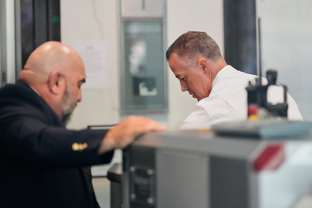 Neuralink CEO Jared Birchall, right, walks through security at the U.S. District Court in Oakland, Calif., Thursday, April 30, 2026. (AP Photo/Godofredo A. Vásquez)