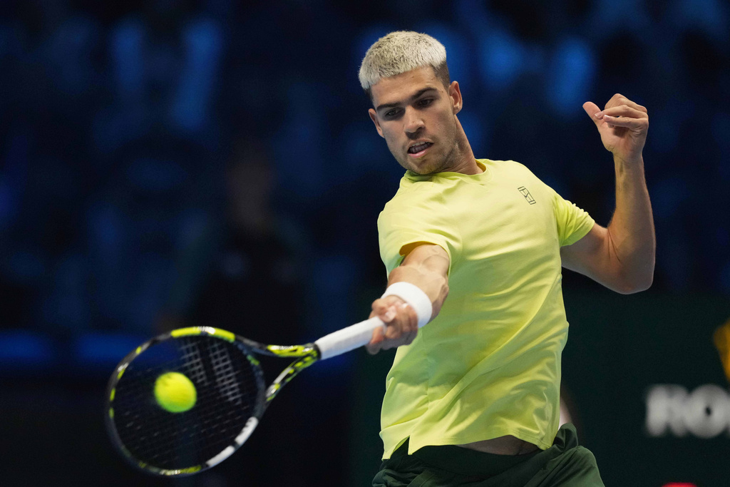 Spain's Carlos Alcaraz returns the ball to Australia's Alex de Minaur during their singles tennis match of the ATP World Tour Finals, in Turin, Italy, Sunday, Nov. 9, 2025. (AP Photo/Antonio Calanni)