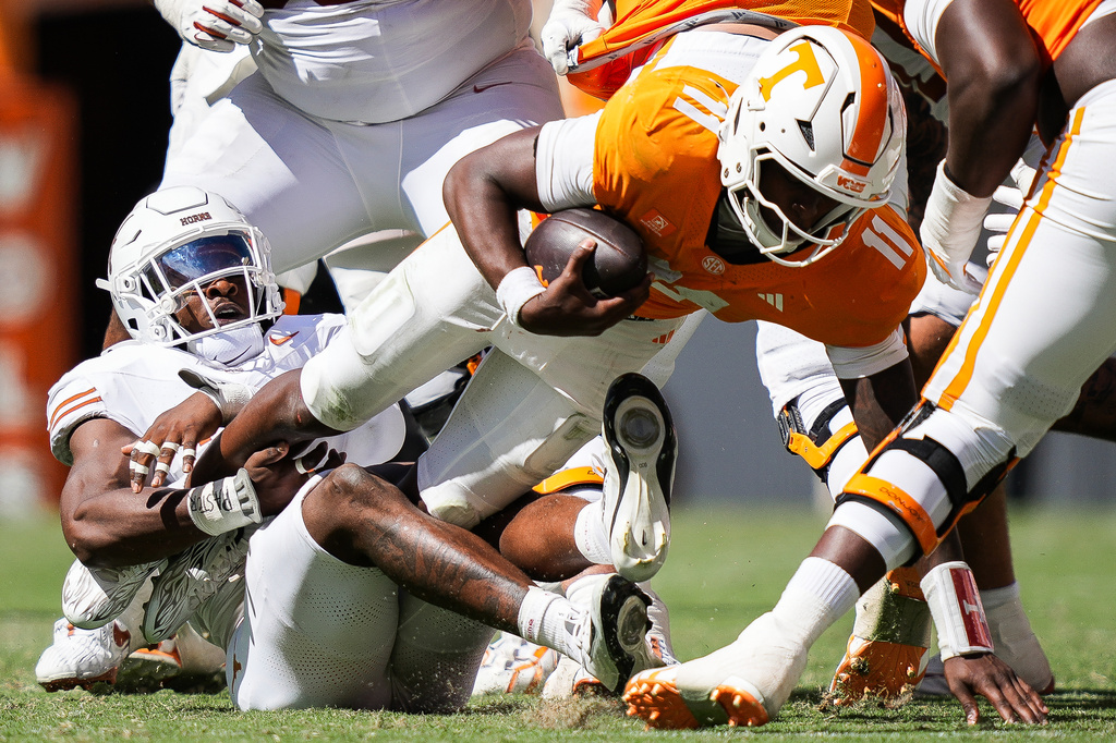 Texas defensive end Colin Simmons (1) brings down Tennessee quarterback Faizon Brandon (11) during the second half of an NCAA college football game in Knoxville, Tenn., Saturday, Sept. 26, 2026. (Sara Diggins/The San Antonio Express-News via AP)