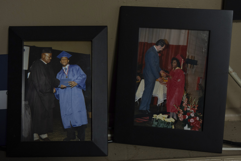 Framed photos of two of Delphine Cherry's children are displayed in her home Friday, Sept. 5, 2025, in Hazel Crest, Ill. Cherry lost two children, Tyler Randolph, left, seen, graduating from high school, and Tyesa Abney, right, seen, graduating from the eight grade, to shootings in and near Chicago. (AP Photo/Carolyn Kaster)