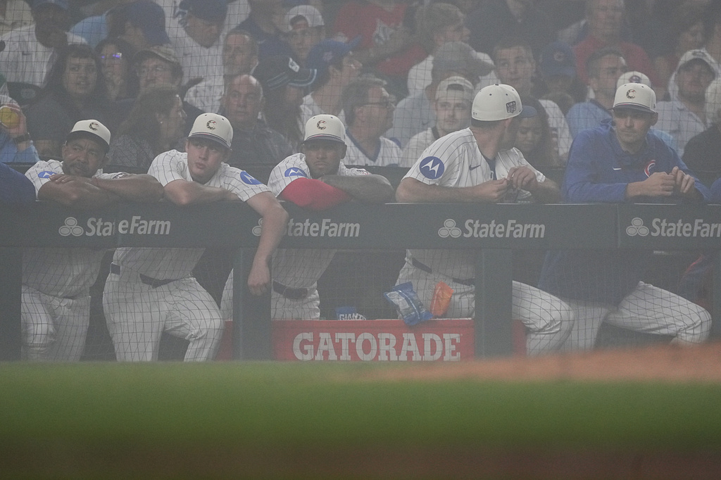 Chicago Cubs stand in the dugout during a fog delay during the sixth inning of a baseball game against the St. Louis Cardinals, Saturday, July 4, 2026, in Chicago. (AP Photo/David Banks)
