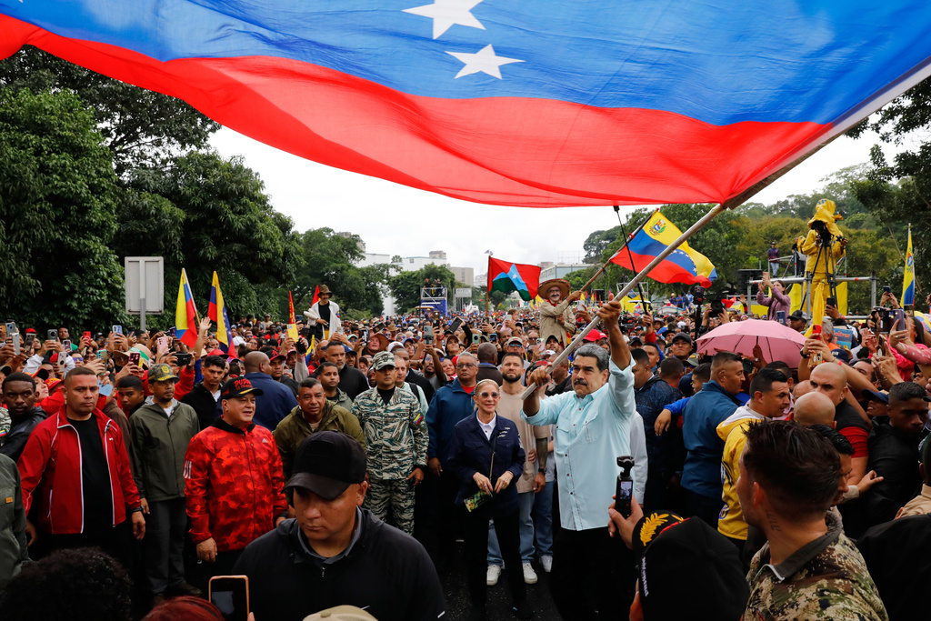 President Nicolas Maduro waves a flag during a rally marking the anniversary of the Battle of Santa Ines, which took place during Venezuela's 19th-century Federal War, in Caracas, Venezuela, Wednesday, Dec. 10, 2025. (AP Photo/Cristian Hernandez)