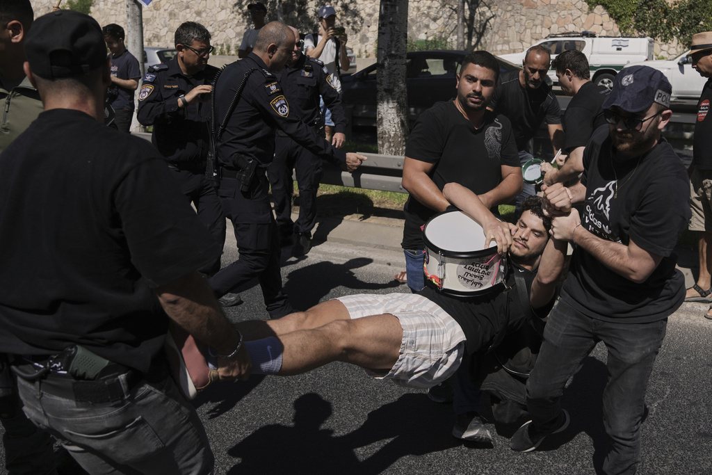 Police officers disperse demonstrators blocking a street during a protest demanding the immediate release of hostages held by Hamas and calling for the Israeli government to reverse its decision to take over Gaza City and other areas in the Gaza Strip, in Jerusalem, Sunday, Aug. 17, 2025. (AP Photo/Mahmoud Illean)