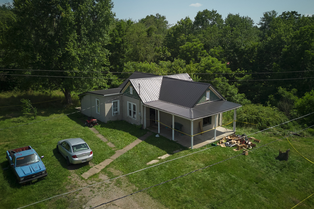 Police tape surrounds a home where authorities say they removed 16 children and arrested four adults in Hamden, Ohio, Wednesday, July 1, 2026. (AP Photo/Carolyn Kaster)